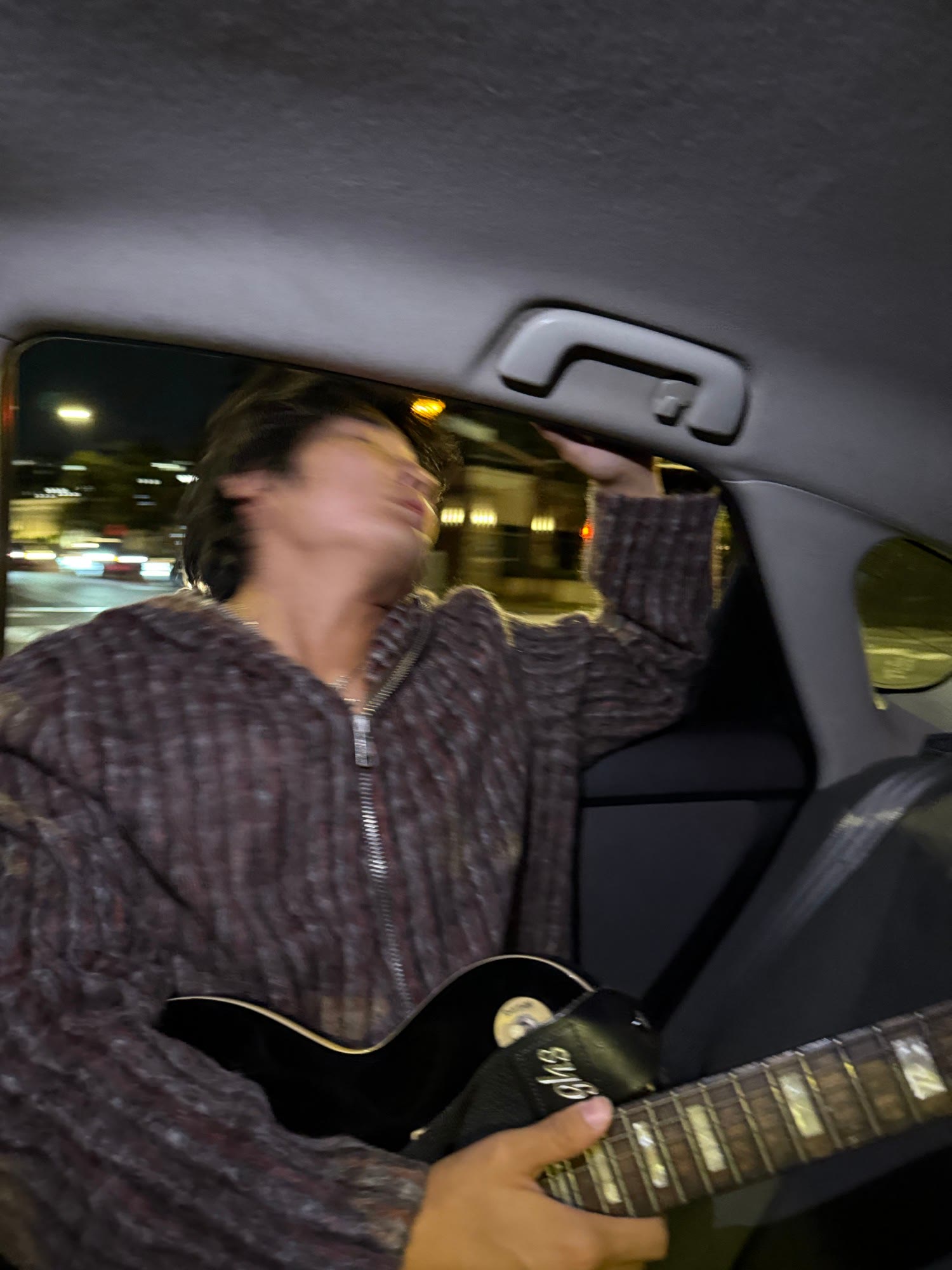 playing guitar in the car at night